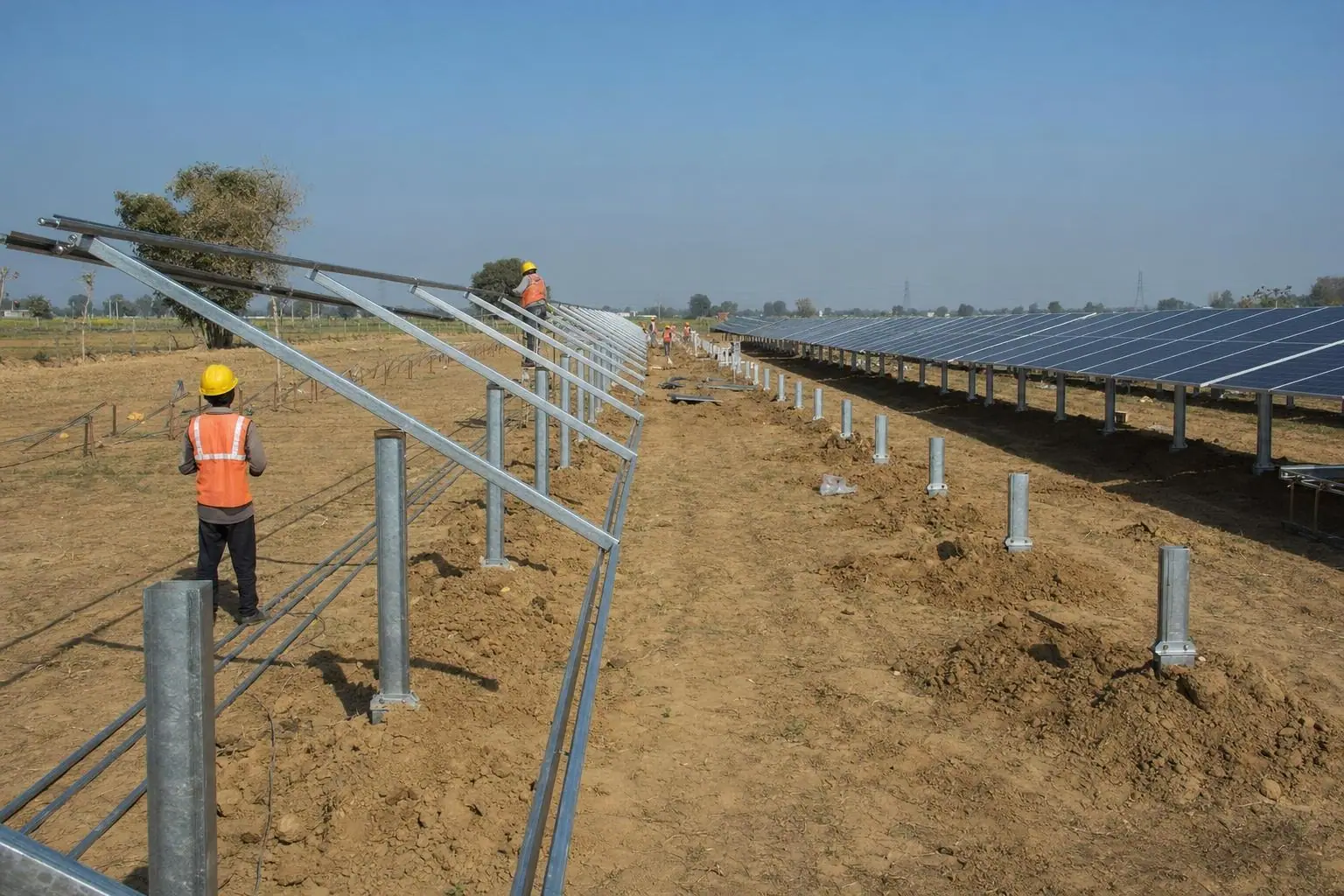 Crew fixing galvanised mounting structures for a ground-mounted solar plant